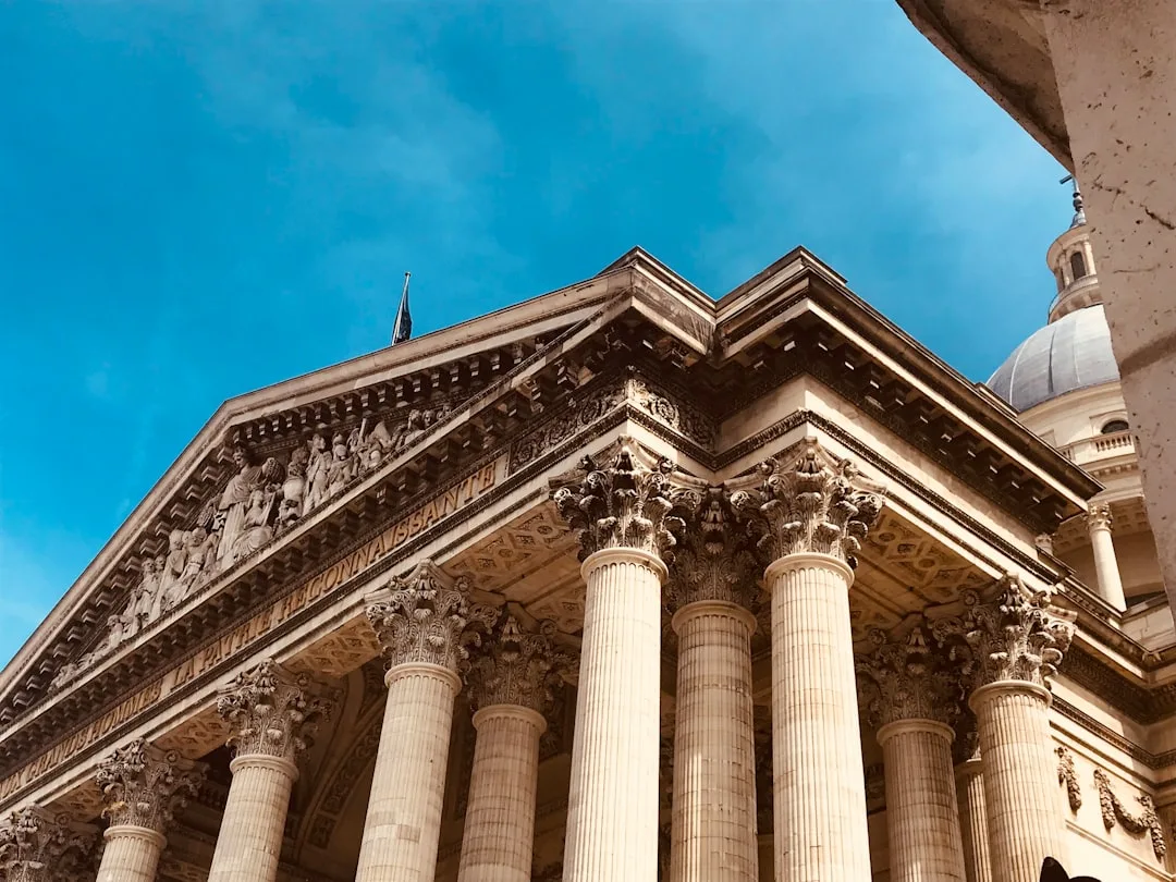 Façade néoclassique d'un tribunal parisien avec colonnes blanches et marches en pierre
